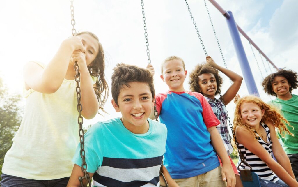 Four children standing by swings