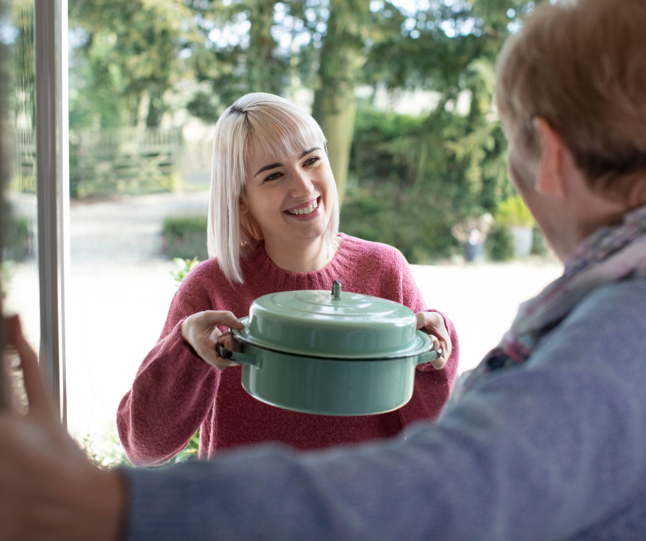 A woman bringing her neighbor a meal
